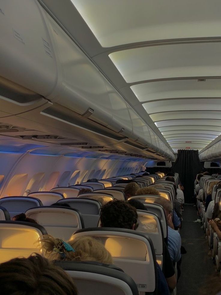 the inside of an airplane with people sitting on seats