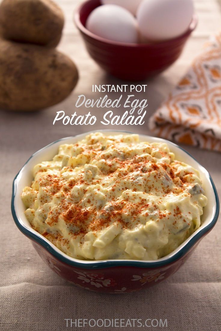 an egg potato salad in a red bowl on top of a table with other ingredients