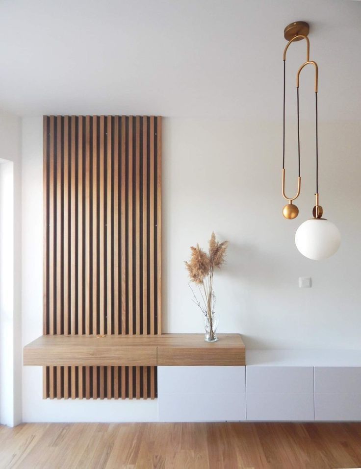 an empty room with wood paneling and white furniture in the center, along with two hanging lights