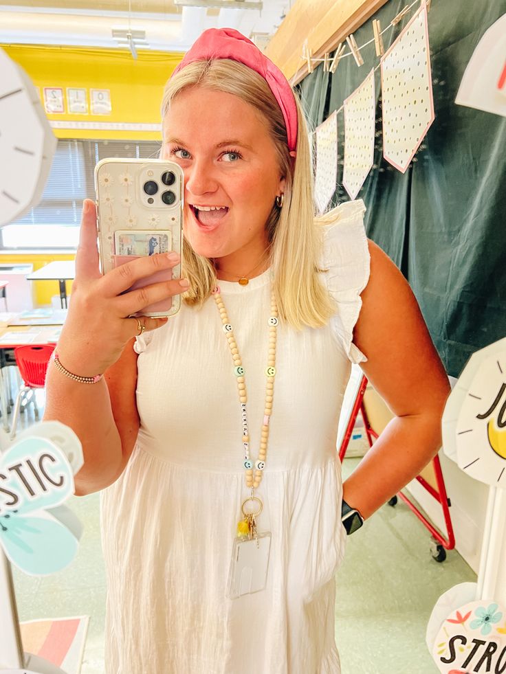 a woman taking a selfie with her cell phone in front of a store display