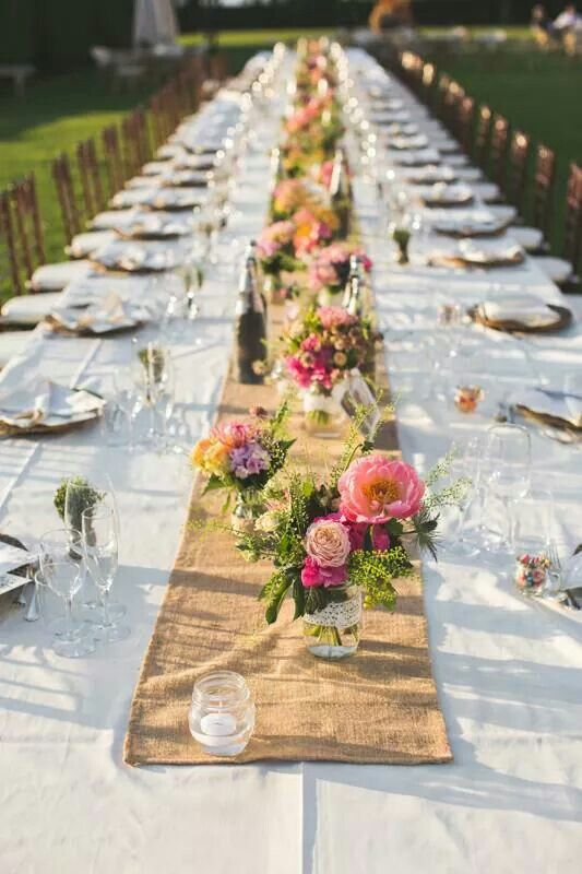 a long table is set with flowers and place settings