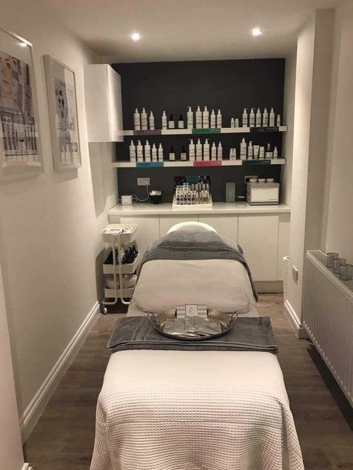 a spa room with two massage tables and bottles on the wall