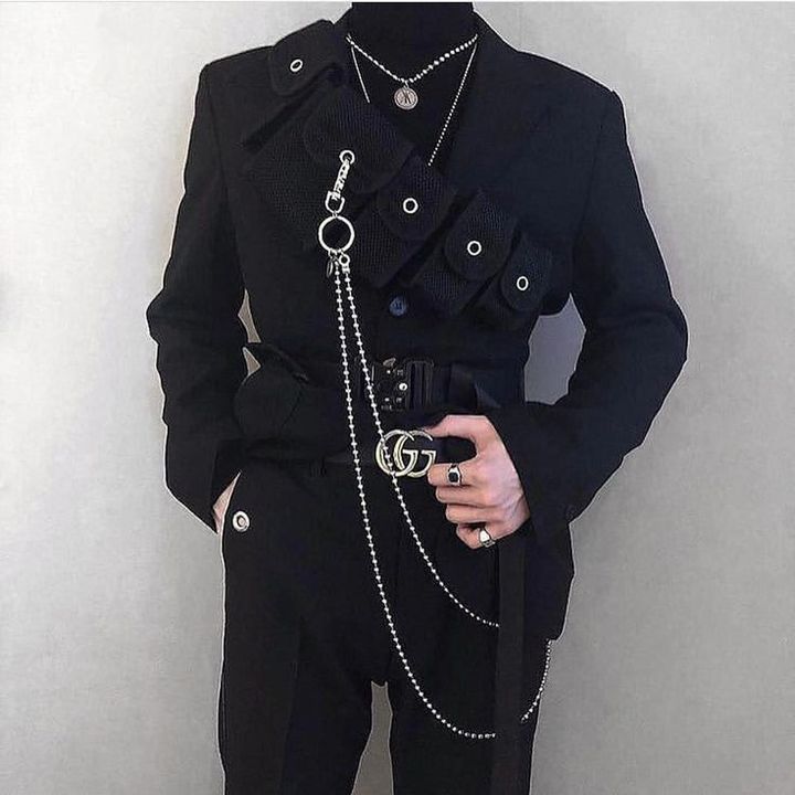 a man in a black outfit with chains around his waist