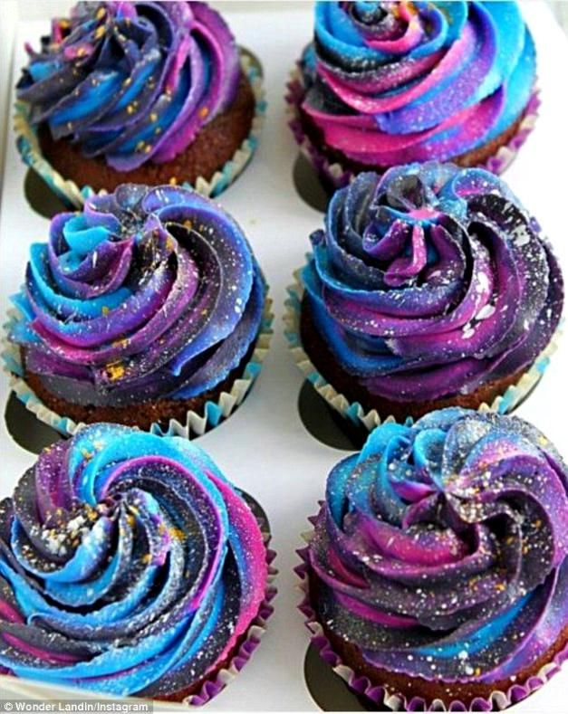 cupcakes with purple and blue frosting in a box