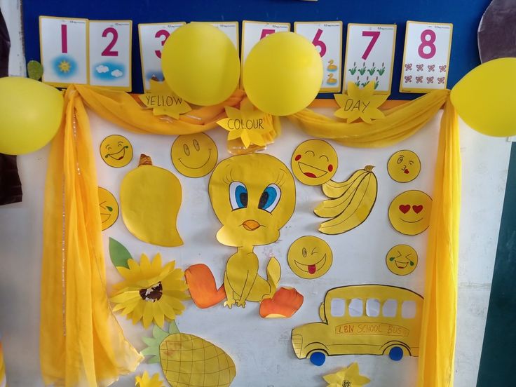 a bulletin board decorated with yellow balloons and decorations