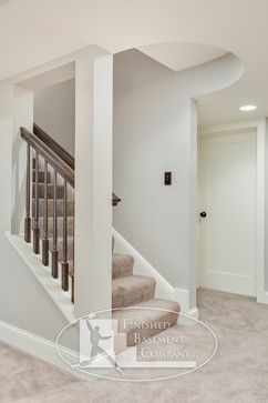 an empty living room with stairs and carpet