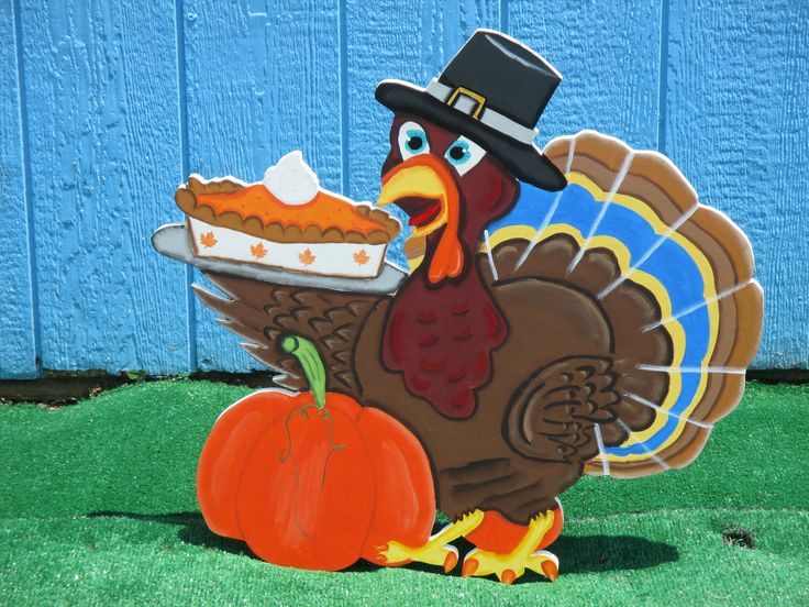 a turkey with a pie on it's plate in front of a blue wall