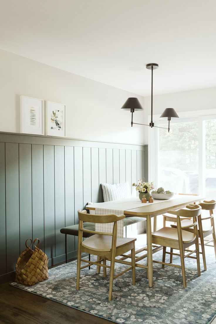 a dining room table with four chairs and a bench in front of a window that looks out onto the yard