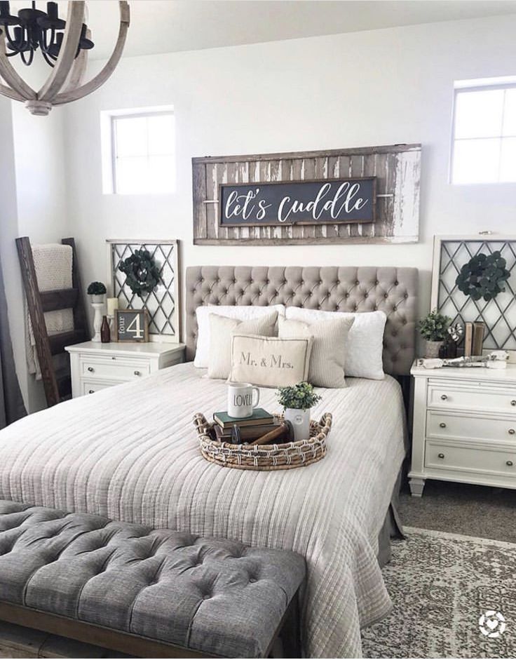 an instagram photo of a bedroom with white furniture and gray bedding, including a chandelier