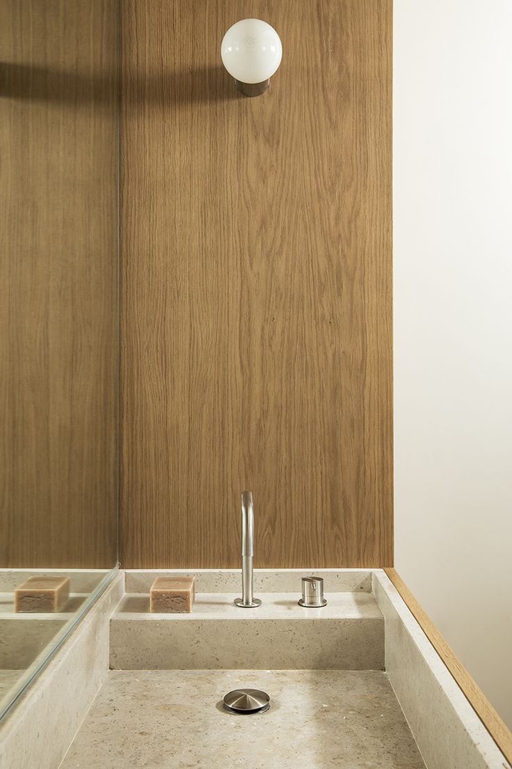 a bathroom sink with a wooden wall behind it