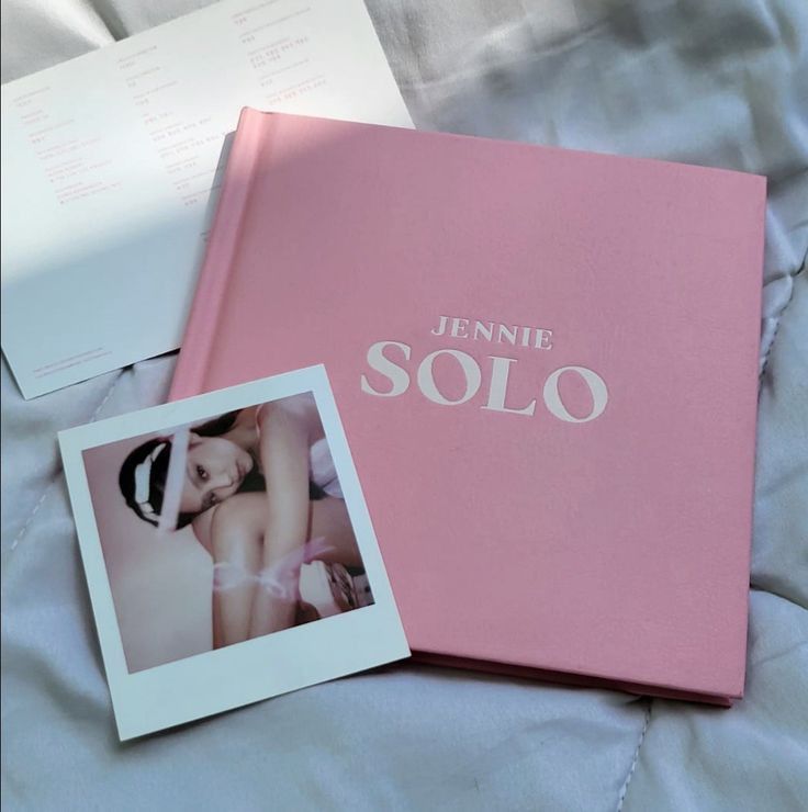 a pink book with the word'jennyne solo'is laying on a bed