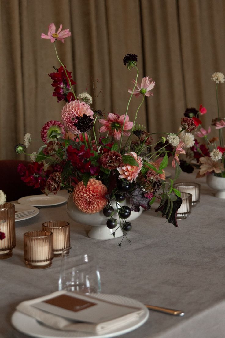 the table is set with flowers and candles