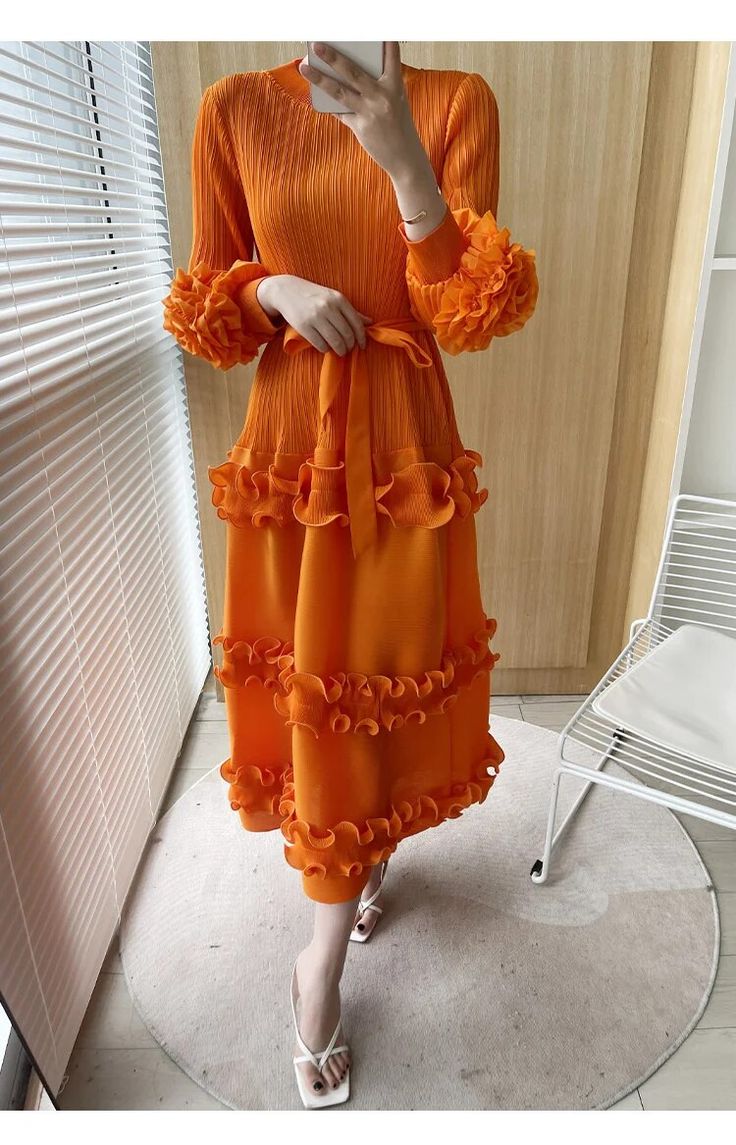 Enhance your style with our Bella Orange Floral Pleated Sleeve Dress. Ideal for any occasion, this dress effortlessly combines elegance and vibrancy through its pleated sleeves and floral details. Be ready to embrace the beauty of the season in this chic and comfortable outfit. Fit & Size Size Bust Length Sleeve Length Shoulder One Size 35.43 - 46.46" 47.24" 19.69" 15.75" Chic Orange Long Sleeve Dress, Spring Maxi Length Pleated Dress With Ruffles, Spring Midi-length Pleated Dress With Ruffles, Elegant Spring Pleated Dress With Ruffles, Modest Spring Evening Midi Dress, Spring Midi Dress With Pleated Sleeves, Knee-length, Fall Chiffon Midi Dress With Ruffles, Modest Midi Dress For Spring Evening, Modest Evening Midi Dress For Spring