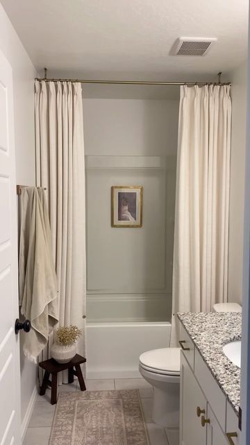 a bathroom with a white toilet sitting next to a bath tub under a shower curtain