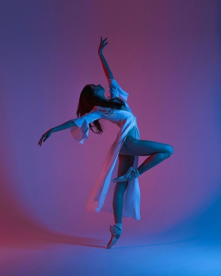 a woman is dancing in the air with her arms spread out and legs bent forward