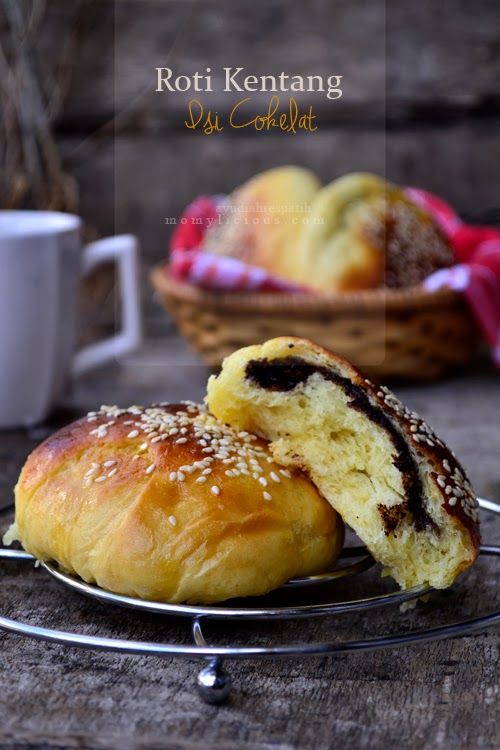 two rolls on a wire rack next to a cup of coffee and basket of bread