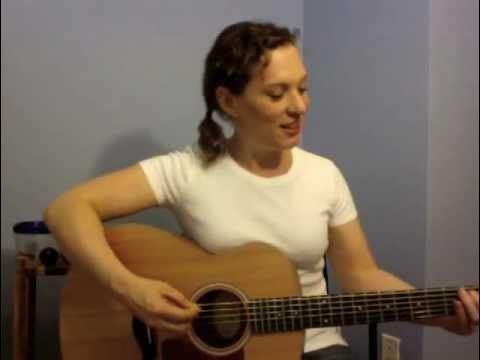 a woman is playing an acoustic guitar in the room