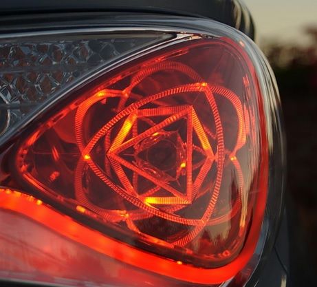 the tail light of a car with an intricate design on it's rear end