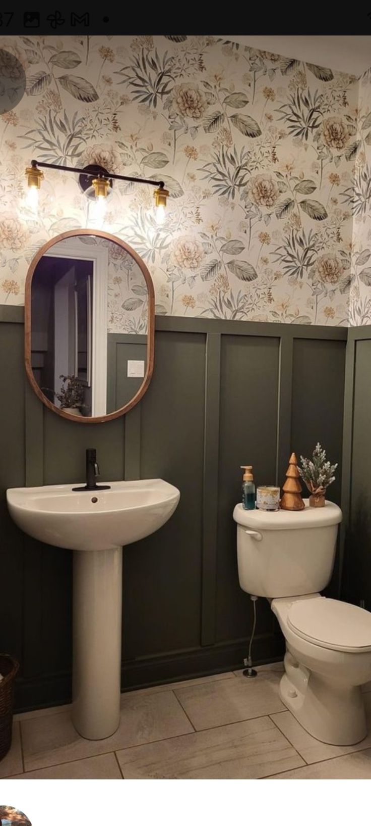 a white toilet sitting next to a bathroom sink under a mirror on top of a wall