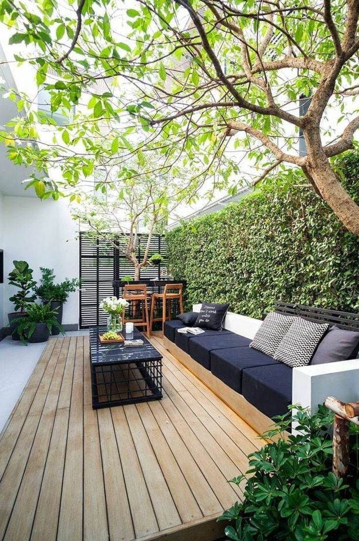 an outdoor living area with couches, tables and potted plants on the deck