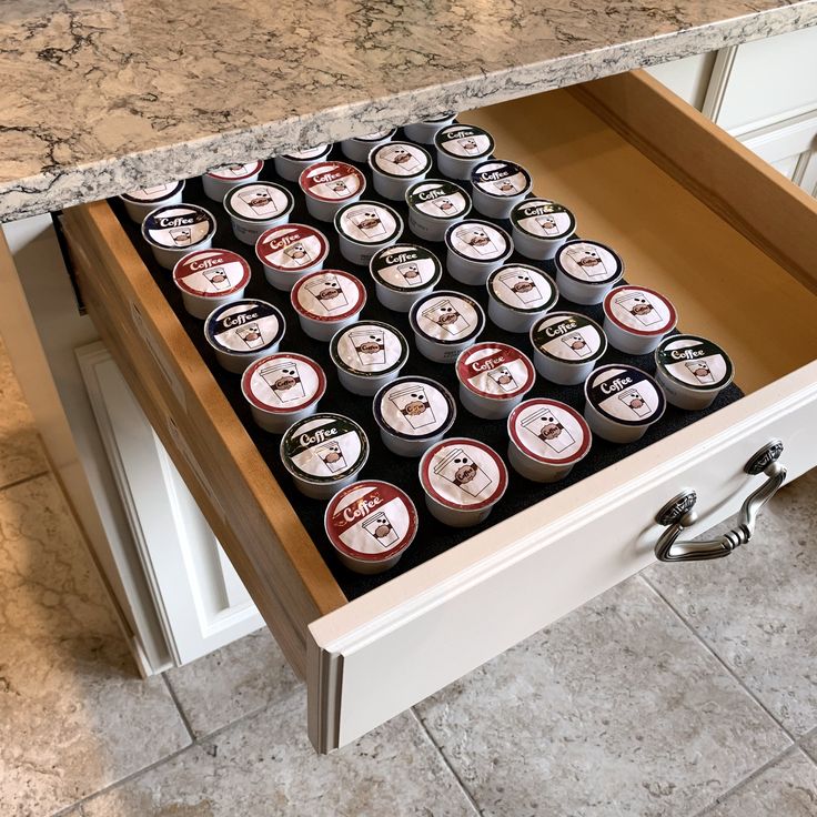 an open drawer in a kitchen filled with lots of beer cans on top of a counter