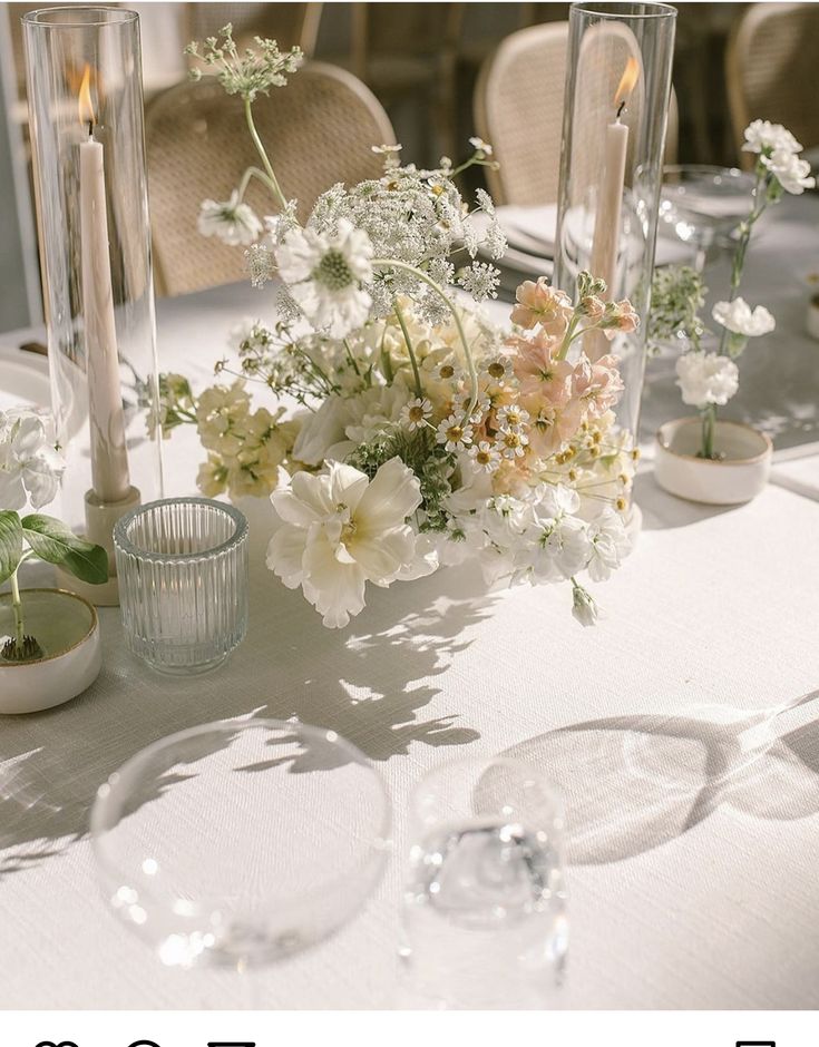 the table is set with flowers and candles