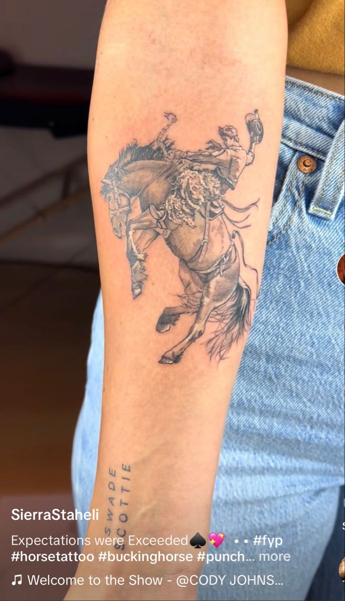 a man with a tattoo on his arm riding a horse and holding a lasso