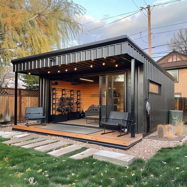 an outdoor living area with black furniture and wooden steps leading up to the back door