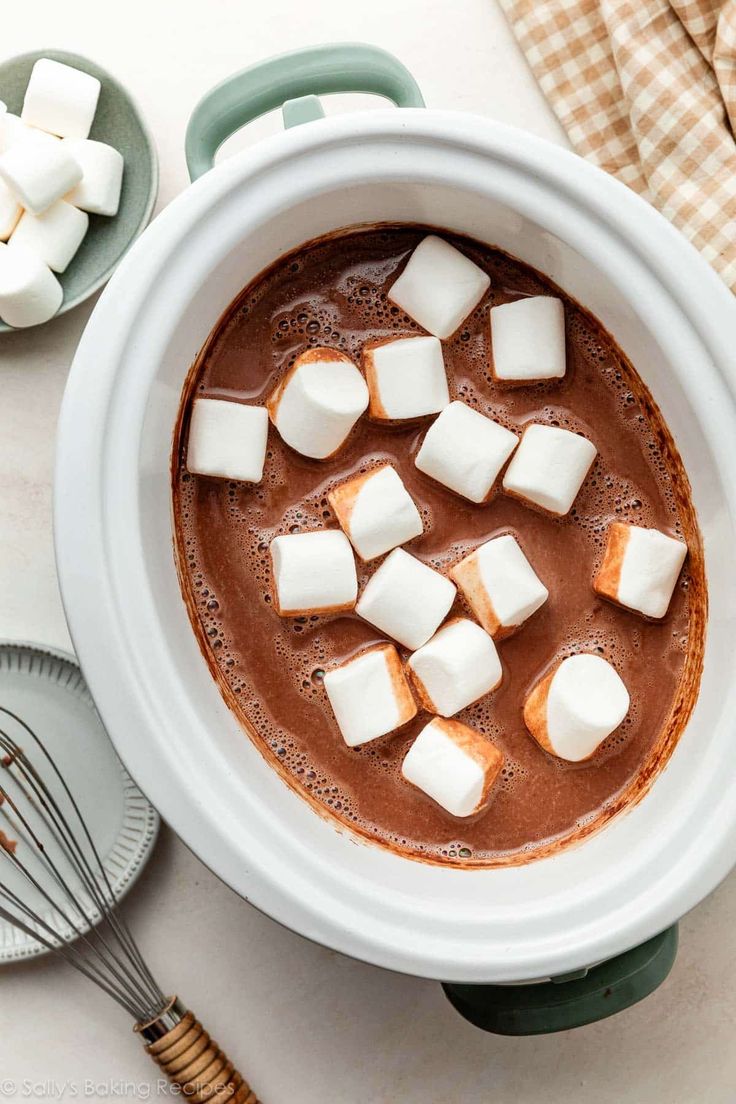 a bowl filled with hot chocolate and marshmallows on top of a table