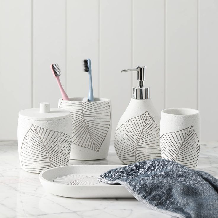 three toothbrushes and two soap dispensers on a marble counter