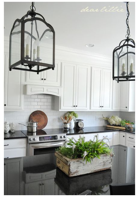 a kitchen filled with lots of white cabinets and black counter top space next to an oven