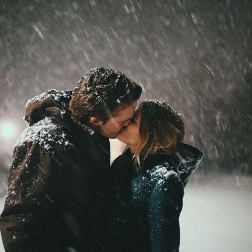 a man and woman kissing in the snow