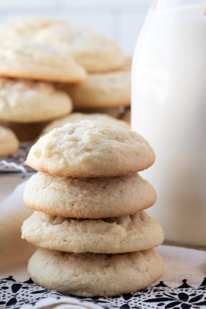 a stack of cookies sitting on top of a table next to a glass of milk