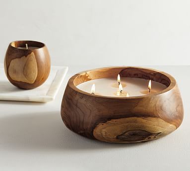 two wooden candles sitting on top of a white plate next to each other and one candle in the middle