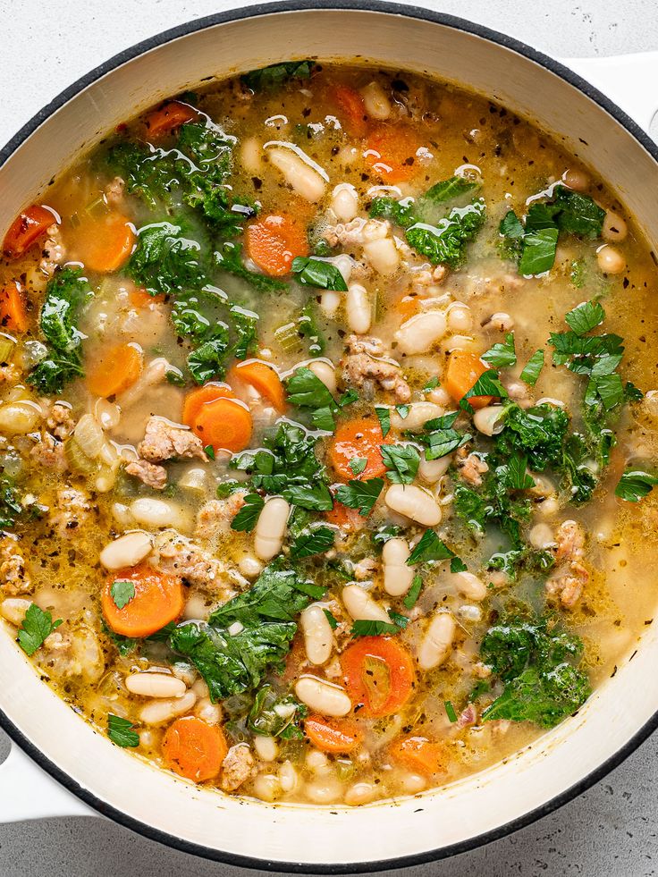 a pot filled with soup and vegetables on top of a table