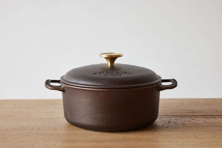 a brown casserole sitting on top of a wooden table next to a white wall