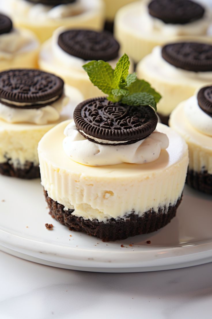 oreo cookies and cream cheesecakes on a white plate with a mint sprig