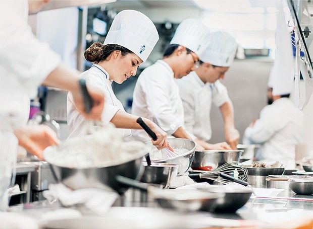 the chefs are preparing food in the kitchen