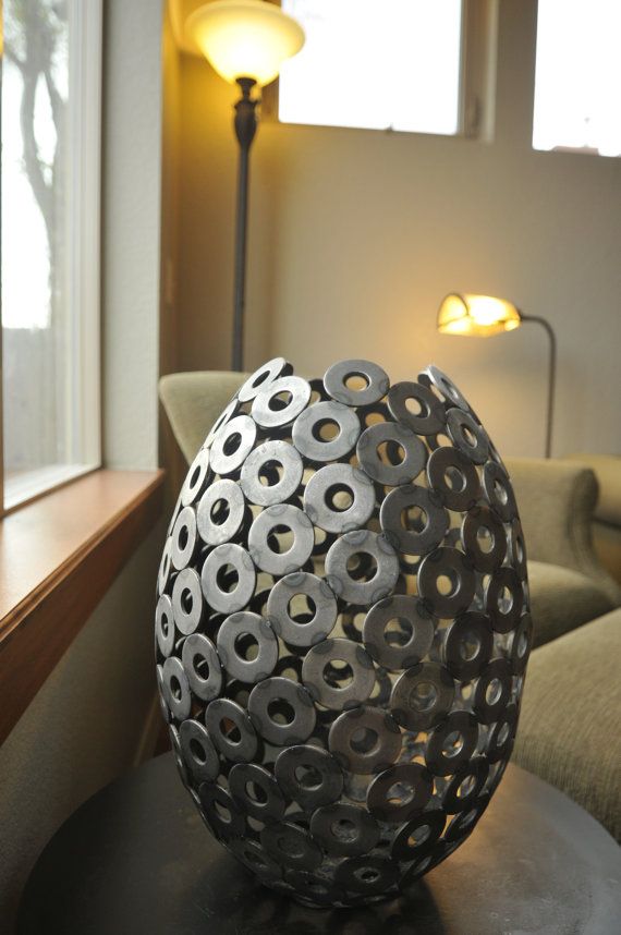 a large metal ball sitting on top of a wooden table next to a window in a living room