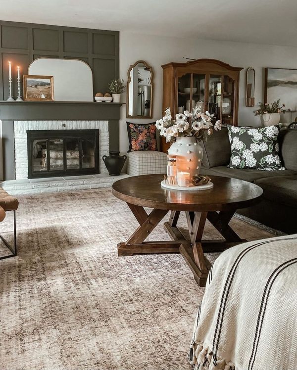 a living room filled with furniture and a fire place next to a fireplace covered in candles