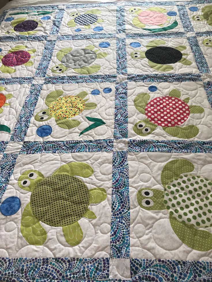 a quilted bed spread with turtle designs on it