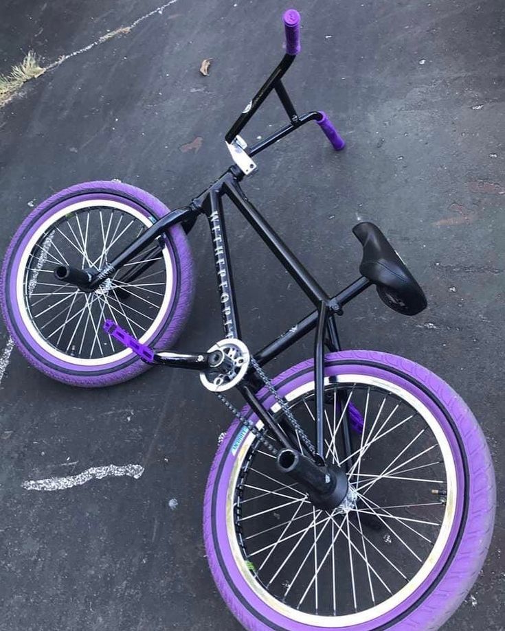 a black and purple bike is parked on the pavement