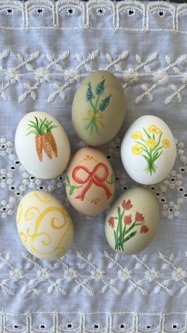 six decorated eggs sitting on top of a doily