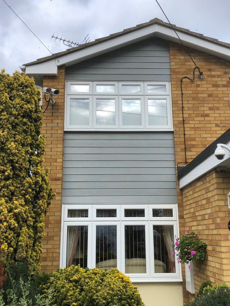 a grey house with white trim and windows