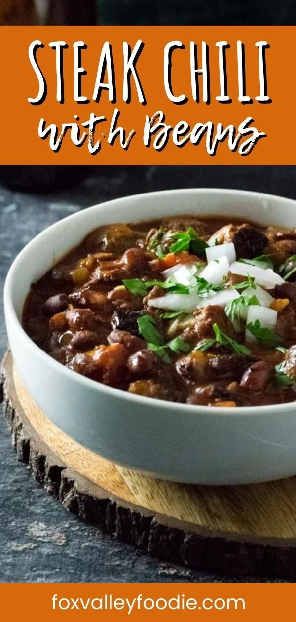 a bowl of steak chili with beans and onions