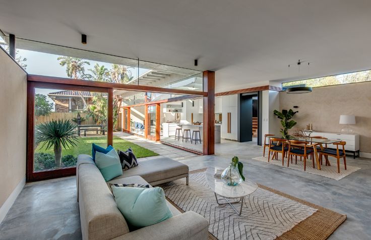 a living room filled with furniture next to a large glass doored window covered patio