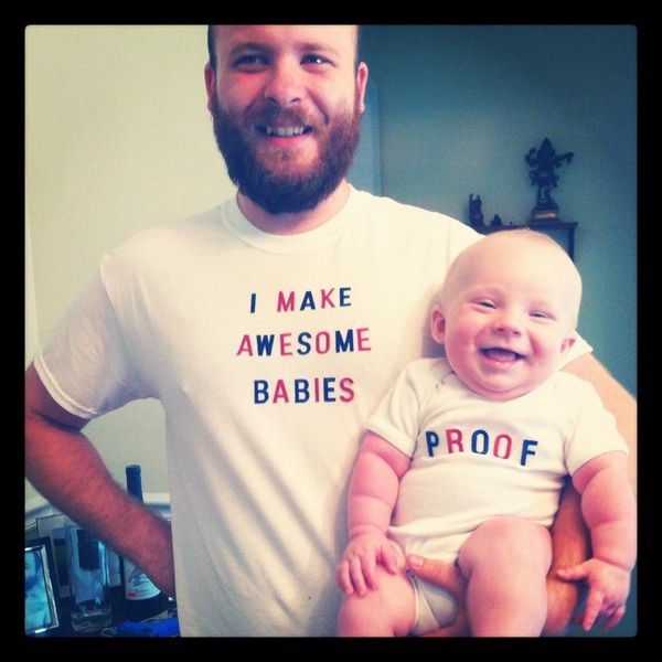 a man holding a baby in his arms with the words i make awesome babies on it