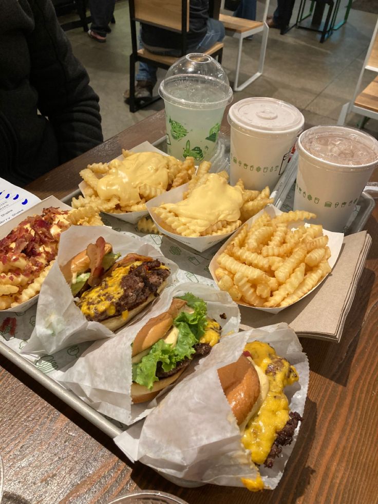 a tray filled with different types of food on top of a table next to drinks