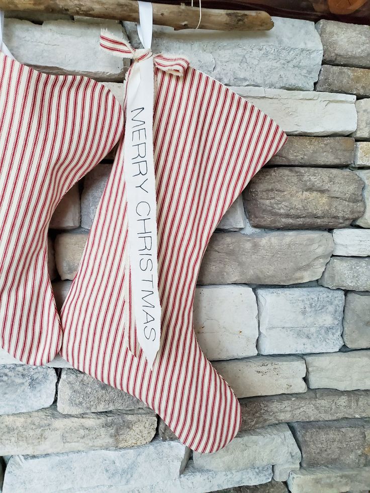 a red and white striped christmas stocking hanging on a brick wall