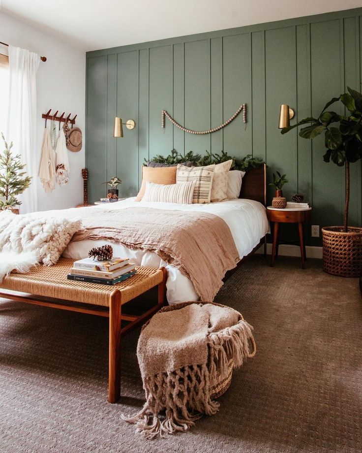 a bed room with a neatly made bed next to a table and two plants on the wall